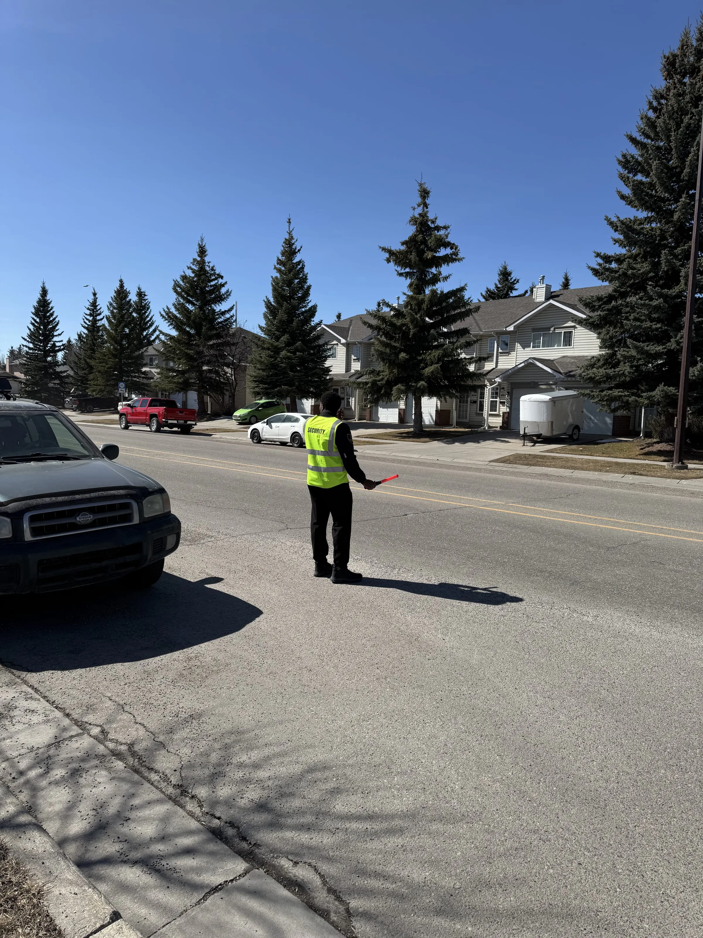 Guard Tower Security guard directing vehicles in a tree-lined neighbourhood
